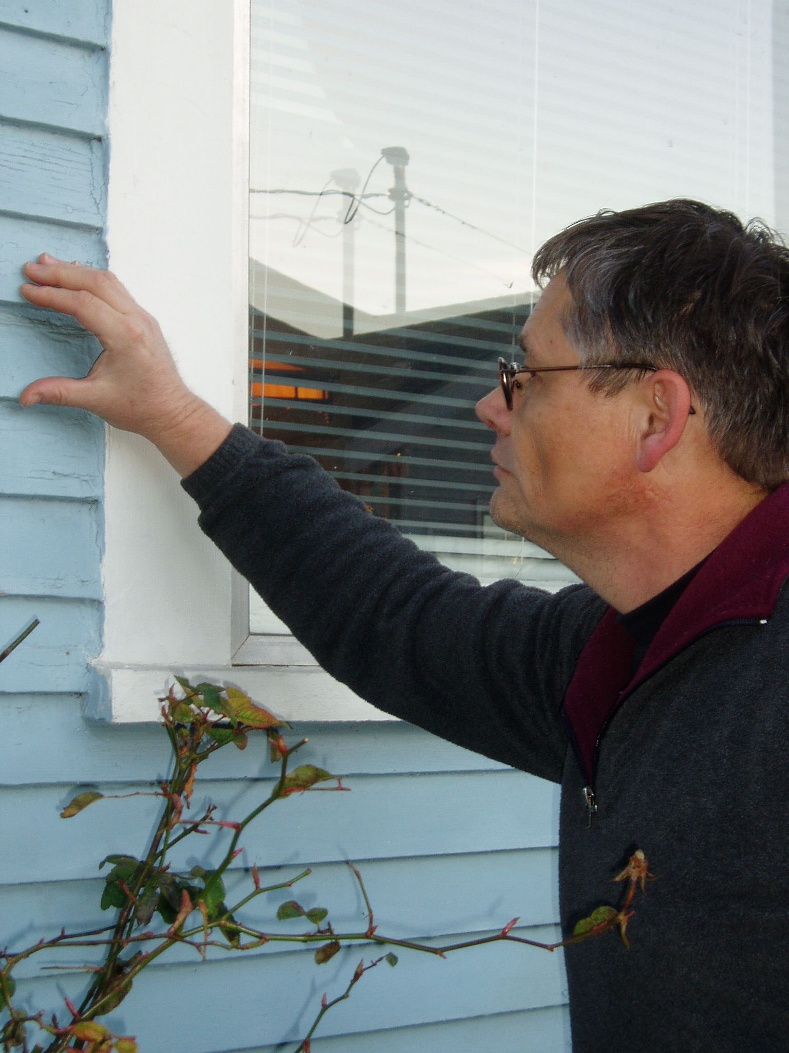 Steven Smith inspects cedar siding Photo