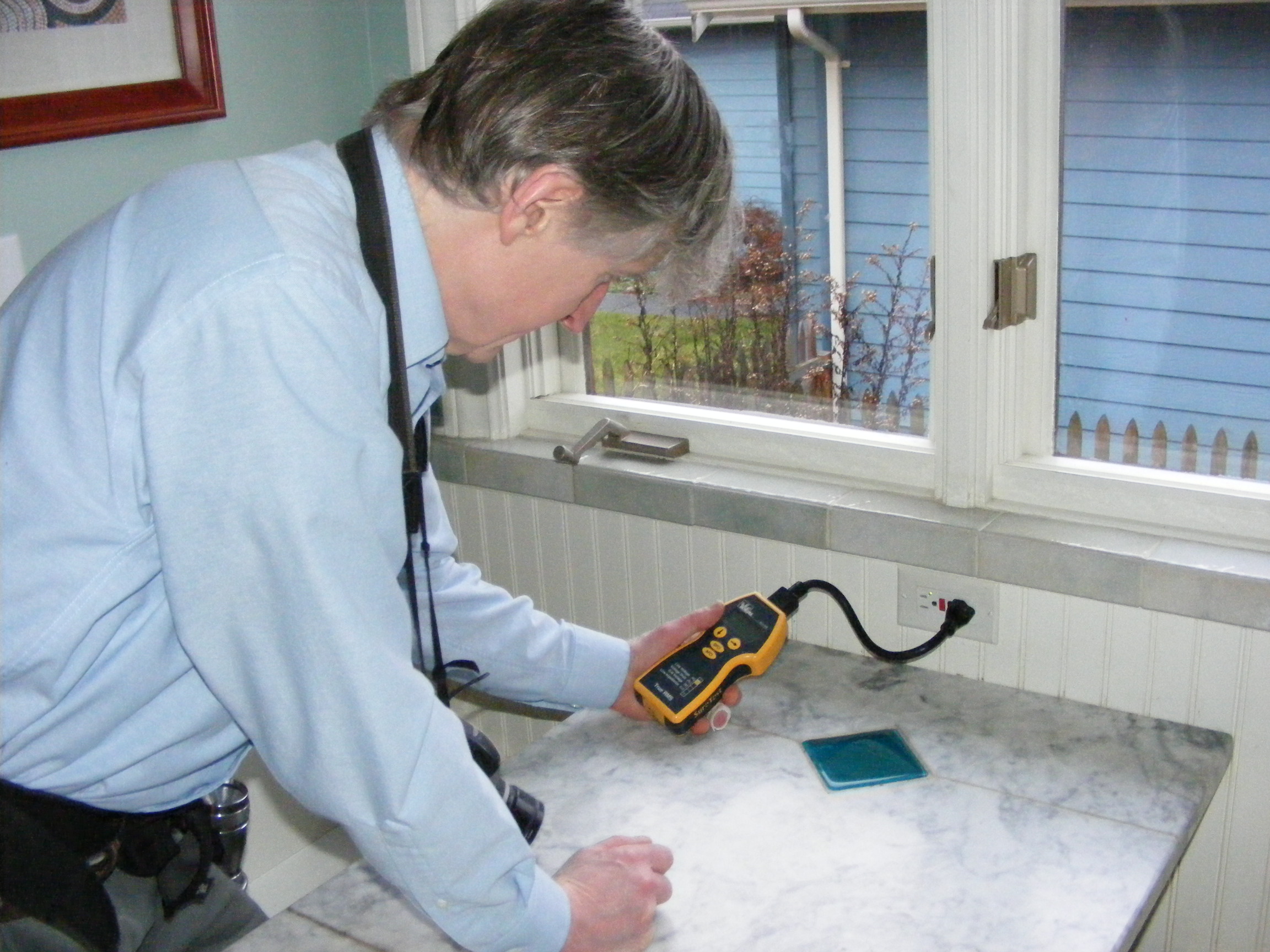 Charles Buell tests a GFCI outlet Photo